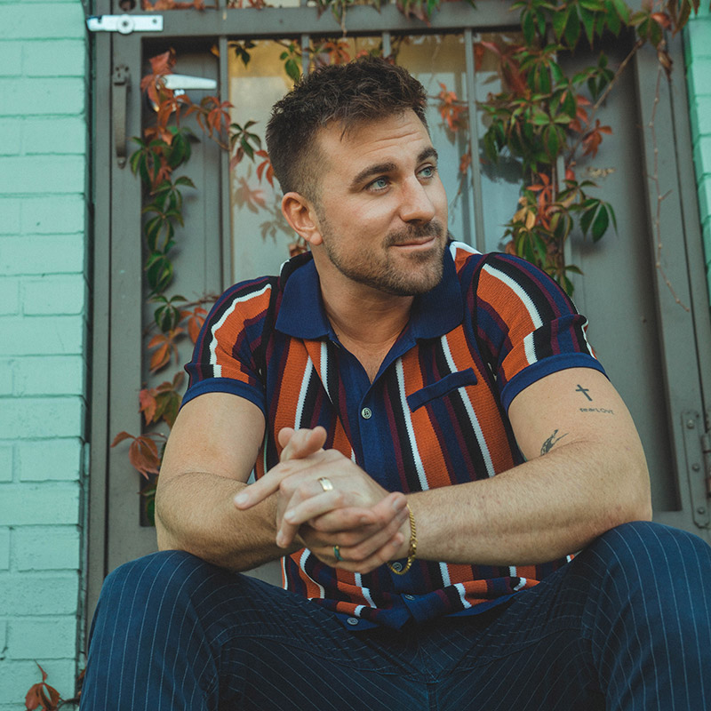Dom Liberati sitting in front a door decorated with vines