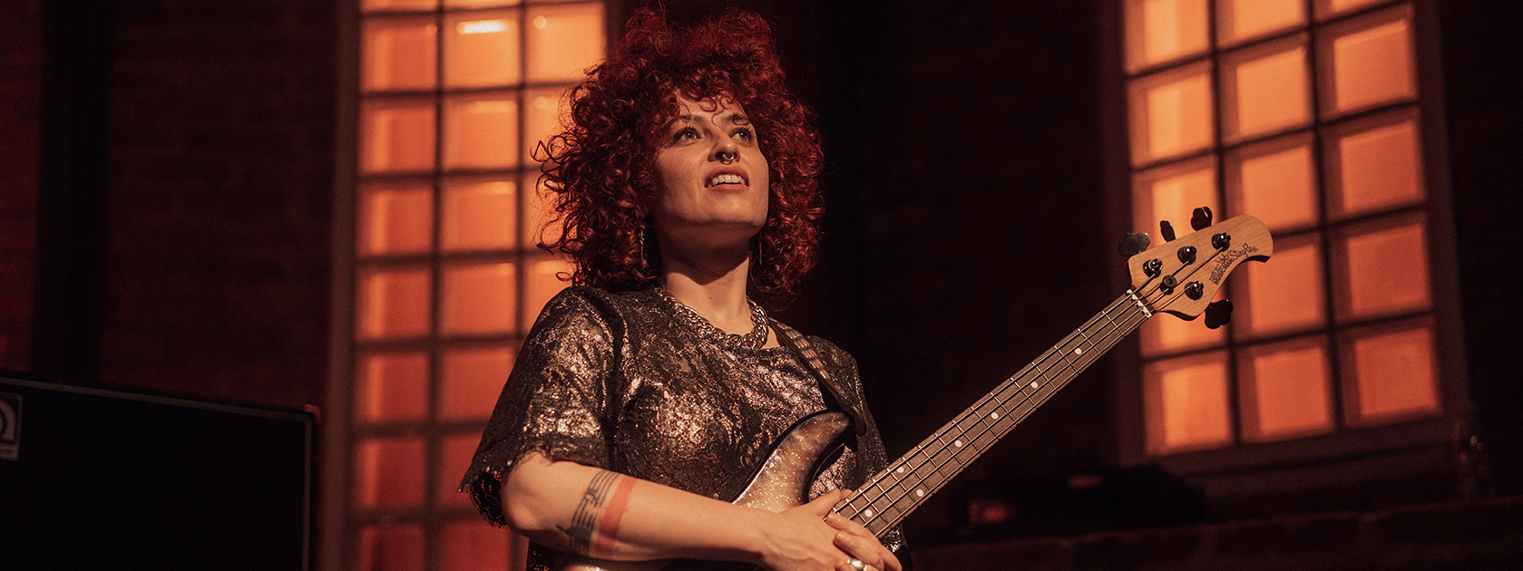 Pops Magellan on stage holding her bass