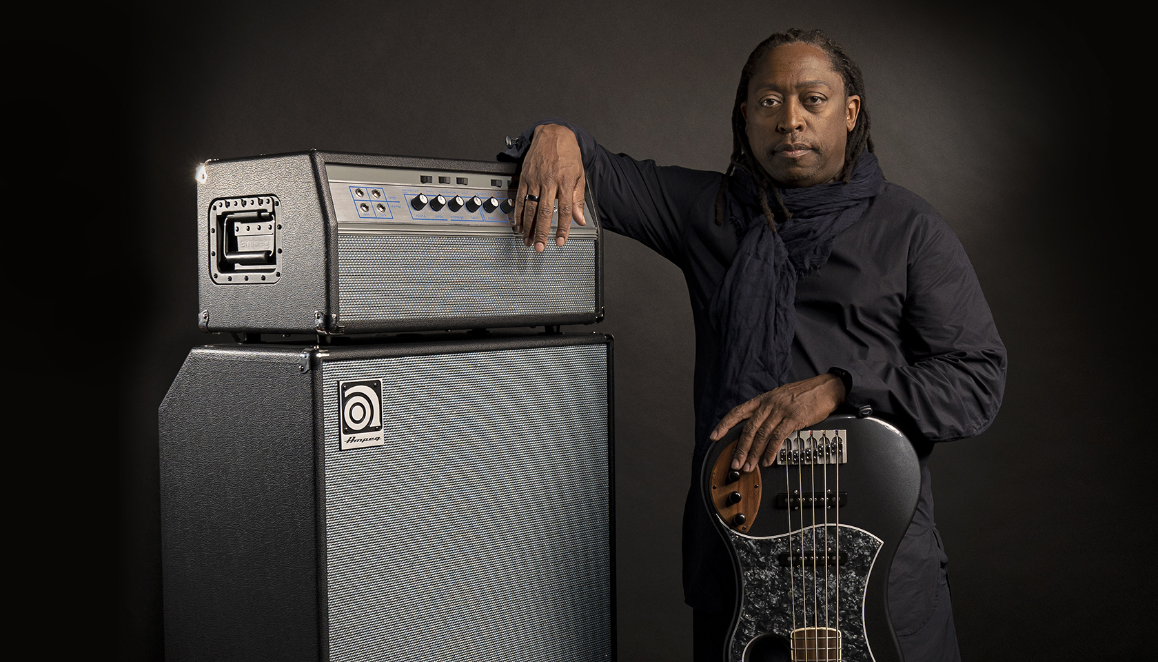Darryl Jones leaning against an Ampeg stack and upside down bass